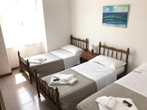 a group of four beds in a room at Prince Apartment in Levanto