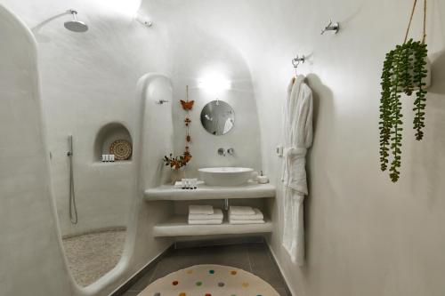 um banheiro branco com pia e chuveiro em Mellow Luxury Cave em Oia