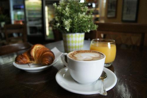 a cup of coffee and a croissant and a glass of orange juice at hu I Pini village in Fiano Romano