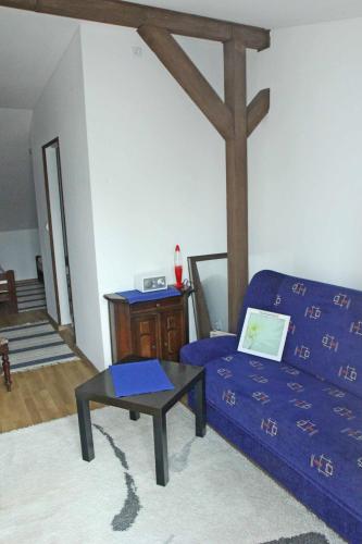 a living room with a blue bed and a table at Dworska Zagroda in Korytowo
