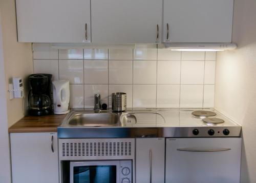 a small kitchen with a sink and a stove at Førde Sommarhotell in Førde