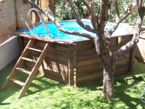 een houten zwembad met een ladder naast een boom bij Villa Némausa / Saint-Aygulf in Saint-Aygulf