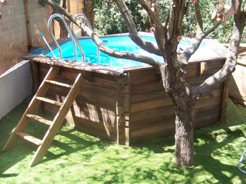 une piscine en bois avec une échelle à côté d'un arbre dans l'établissement Villa Némausa / Saint-Aygulf, à Saint-Aygulf