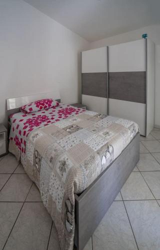 a bedroom with a bed with a red and white blanket at Appartamento Belvedere Sassos P 3267 in Tresnuraghes