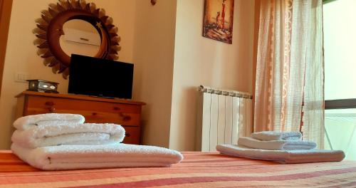 un mucchio di asciugamani su un letto con specchio di I due salentini a Lecce