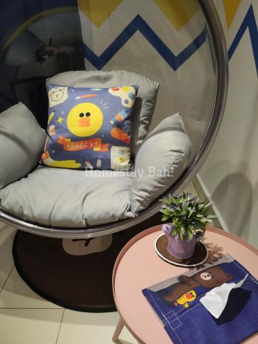a chair with a pillow next to a table at Homestay Bah! in Kota Kinabalu