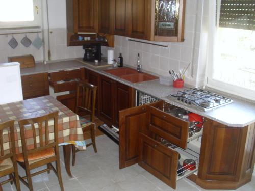 a kitchen with wooden cabinets and a counter top at PIETRAMURATA APPARTAMENTO VISTA MONTAGNA terzo piano in Dro