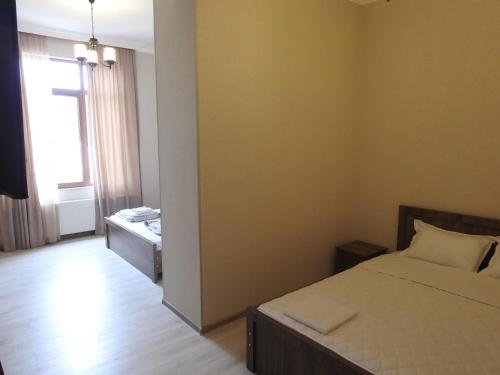 a small bedroom with a bed and a window at White Hotel Guesthouse in Zugdidi