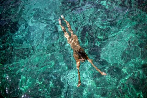 a person laying on their back in the water at Koversada Apartments Naturist Park in Vrsar