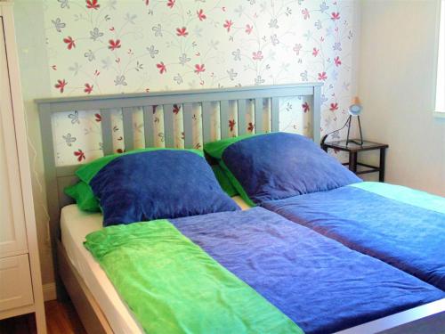 a bedroom with two beds with blue and green sheets at Bungalow in Damshagen nahe der Ostsee in Reppenhagen