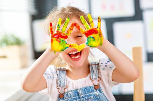 a little girl with her hands painted in paint at STELLA Resort & SPA in Władysławowo