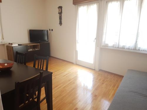 a living room with a dining table and a television at Appartamento Valle dei Laghi in Calavino