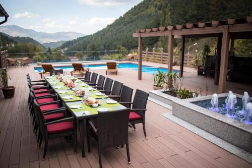 a table and chairs on a patio with a pool at Best Western Plus Paradise Hotel Dilijan in Dilijan