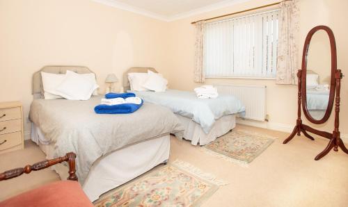 2 camas individuales en una habitación con espejo en Luxury House in Warsash. en Warsash