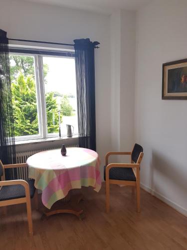 een kamer met een tafel, 2 stoelen en een raam bij Gamla Macken in Margretetorp