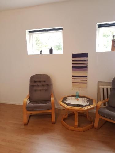 een woonkamer met 2 stoelen en een salontafel bij Gamla Macken in Margretetorp