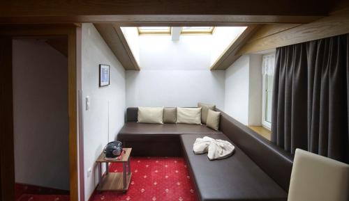 a living room with a couch and a window at B&B Gästehaus Alpenblick in Lermoos