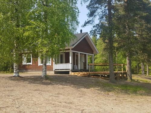 een klein huis met een veranda en een hek bij Camping Atrain in Kuopio