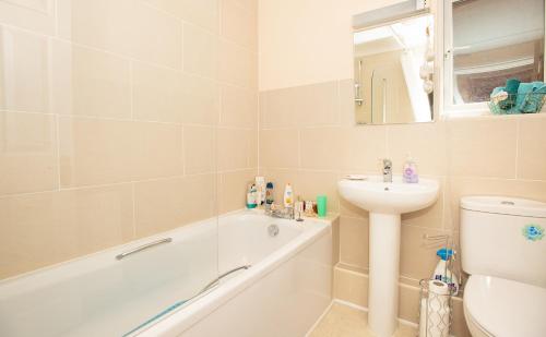 a bathroom with a tub and a sink and a toilet at Luxury House in Warsash. in Warsash