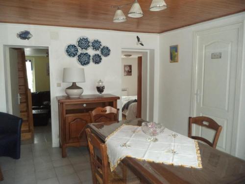 une salle à manger avec une table et des assiettes murales dans l'établissement Maison de vacances à Créances, à Créances