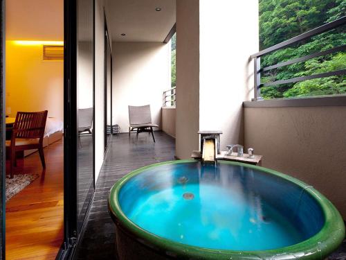 a bathroom with a large blue tub in a room at Hanare Matsushimakaku in Aizuwakamatsu