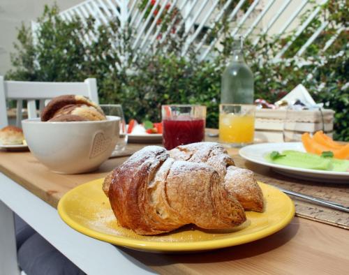 a table with a plate of bread and a bowl of fruit at I Colori della Puglia Rooms in Trani