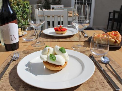 a table with a plate of food and a bottle of wine at I Colori della Puglia Rooms in Trani