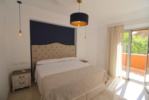 a bedroom with a bed and a large window at Sotogrande - SotoLUX in Sotogrande