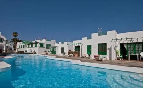 a large swimming pool in front of a building at SUNNY CORNER Apartment in Puerto del Carmen