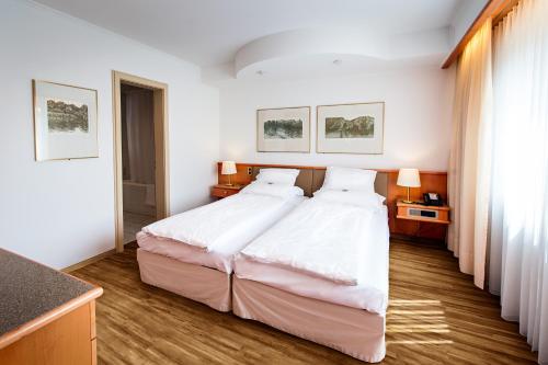 a bedroom with a large bed with white sheets at City Hotel Biel Bienne Free Parking in Biel