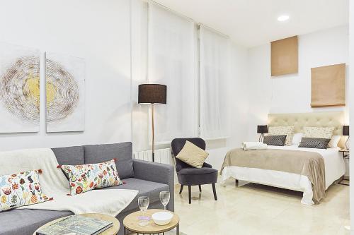 sala de estar con sofá y cama en LEEWAYS APARTMENT IX in GRAN VÍA, en Madrid