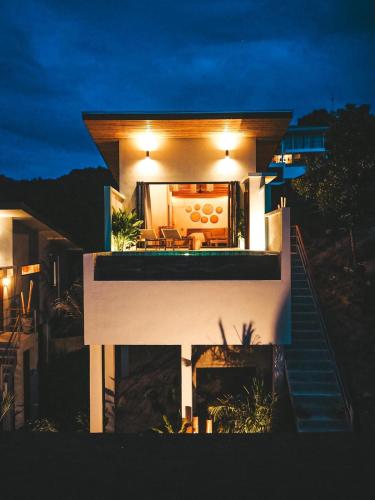 a house with lights on top of it at night at Mayara pool villas - Adults only in Haad Yao