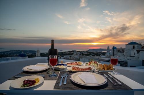 a table with plates of food and a bottle of wine at Labyrinth Traditional Houses in Pyrgos
