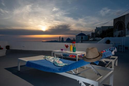 a person with a hat sitting on a chair on a rooftop at Labyrinth Traditional Houses in Pirgos