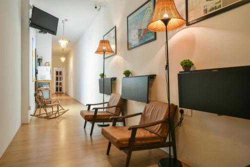 a living room with chairs and a flat screen tv at Ohana House HQ in Melaka
