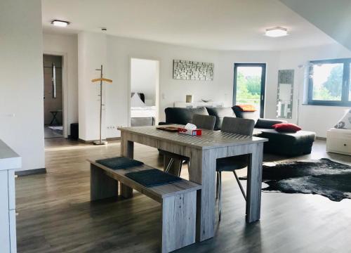 sala de estar con mesa y sofá en LUX Ferienwohnungen, en Hepbach