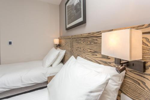 a hotel room with two beds and a lamp at The Aviator, formerly Smugglers Cove, Clacton On Sea by Marston's Inns in Clacton-on-Sea