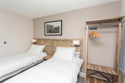 two beds in a room with white walls at The Aviator, formerly Smugglers Cove, Clacton On Sea by Marston's Inns in Clacton-on-Sea