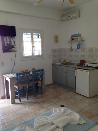 a kitchen with a table and chairs in a room at Villa Costa Studios in Vathi, Sifnos