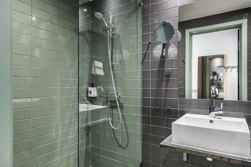 y baño con ducha y lavamanos. en Quality Hotel Pond en Stavanger