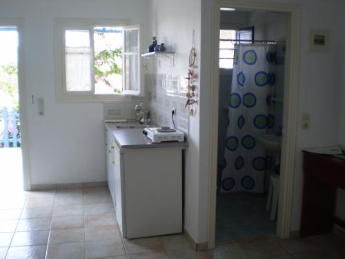 a kitchen with a sink and a refrigerator at Villa Costa Studios in Vathi, Sifnos