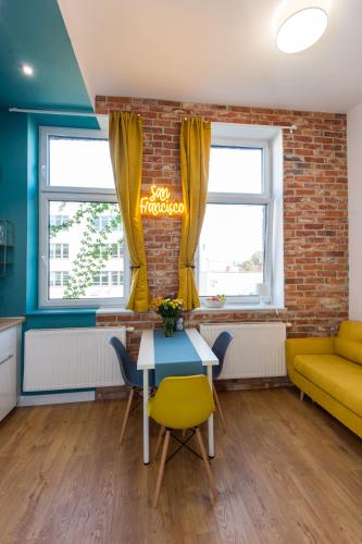 a living room with a table and a yellow couch at Bliss Apartments in Poznań