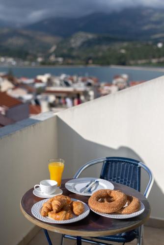 a table with two plates of food and a glass of orange juice at Elegant Living in Argostoli