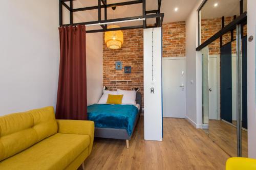 a living room with a couch and a bed at Bliss Apartments in Poznań