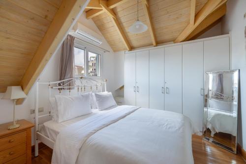 una camera con letto bianco e soffitto in legno di Elegant Living ad Argostoli