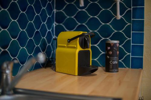 un grille-pain jaune assis sur un comptoir à côté d'une tasse dans l'établissement Baionako Apartamentua, à Bayonne