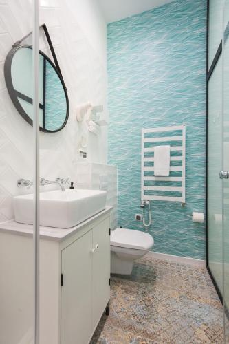a bathroom with a sink and a toilet and a mirror at Bliss Apartments in Poznań