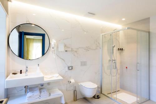 a bathroom with a sink toilet and a mirror at Hotel Gradska Cetinje in Cetinje