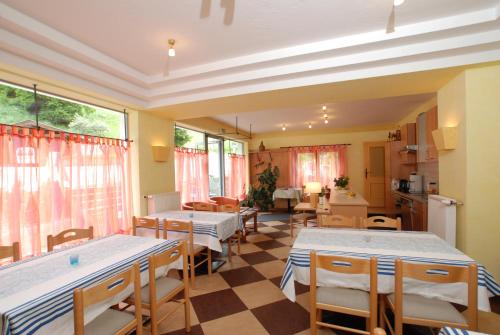 a room with tables and chairs and a kitchen at Landhaus Alpenrose - Feriendomizile Pichler in Heiligenblut