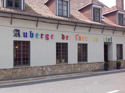 a building with a sign that reads audience be like oil at Auberge de l'Arc en Ciel in Fauquembergues